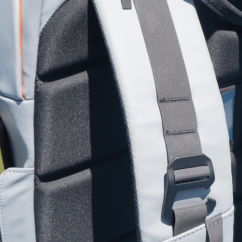 Close-up of a gray padded backpack shoulder strap with an adjustable buckle.