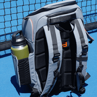 Gray and black backpack with water bottle, placed on blue surface near a tennis net.