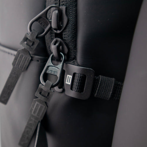 Close-up of black bag zippers and buckles.